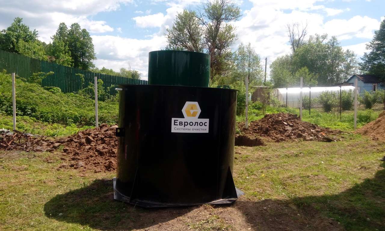Пластиковая станция биоочистки с зелёной крышкой на дачном участке